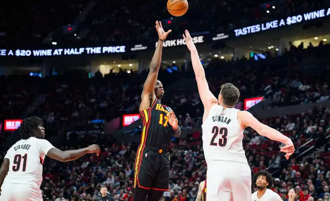 Atlanta Hawks forward Onyeka Okongwu (17) shoots a basket over Portland Trail Blazers center Donovan Clingan (23) during the first half of an NBA basketball game on Thursday, Jan. 15, 2026, in Portland, Ore. (AP Photo/Molly J. Smith)