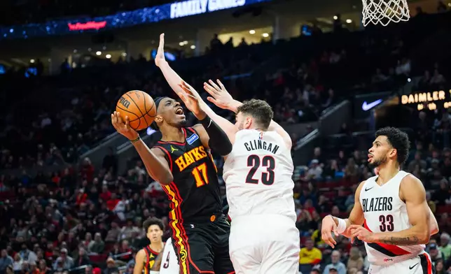 Portland Trail Blazers center Donovan Clingan (23) blocks a basket from Atlanta Hawks forward/center Onyeka Okongwu (17) during the first half of an NBA basketball game on Thursday, Jan. 15, 2026, in Portland, Ore. (AP Photo/Molly J. Smith)
