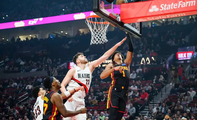 Portland Trail Blazers center Donovan Clingan (23) reaches out to block a basket from Atlanta Hawks forward Jalen Johnson (1) during the first half of an NBA basketball game on Thursday, Jan. 15, 2026, in Portland, Ore. (AP Photo/Molly J. Smith)