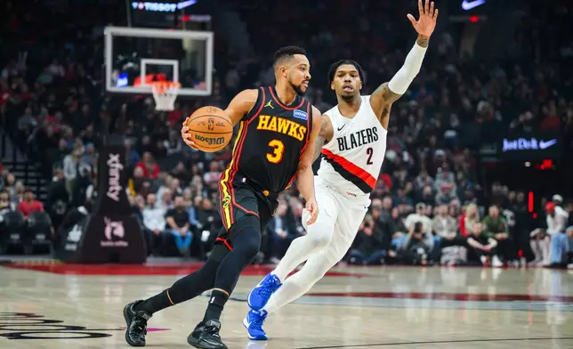 Atlanta Hawks guard CJ McCollum (3) dribbles past Portland Trail Blazers guard Caleb Love (2) during the first half of an NBA basketball game on Thursday, Jan. 15, 2026, in Portland, Ore. (AP Photo/Molly J. Smith)