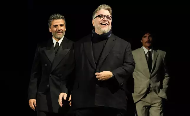 CORRECTS SPELLING OF PERSON SHOWN - Oscar Isaac, from left, Guillermo del Toro, and Jacob Elordi walk onstage during the 37th Palm Springs International Film Festival Film Awards on Saturday, Jan. 3, 2026 at Palm Springs Convention Center in Palm Springs, Calif. (AP Photo/Chris Pizzello)