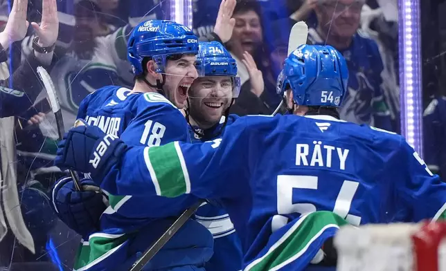Vancouver Canucks' Drew O'Connor (18), Jake DeBrusk (74) and Aatu Raty (54) celebrate O'Connor's goal against the Anaheim Ducks during the third period of an NHL hockey game, in Vancouver, British Columbia, Thursday, Jan. 29, 2026. (Darryl Dyck/The Canadian Press via AP)