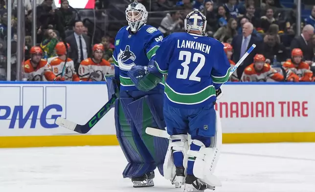 Vancouver Canucks goalie Nikita Tolopilo, left, comes back into the game after goalie Kevin Lankinen started the second period of an NHL hockey game against the Anaheim Ducks, in Vancouver, British Columbia, Thursday, Jan. 29, 2026. (Darryl Dyck/The Canadian Press via AP)