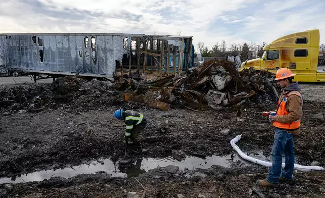 A cleanup crew detects and decontaminates water in a ditch during a tour of the UPS plane crash site, Tuesday, Jan. 13, 2026, in Louisville, Ky. (AP Photo/Jon Cherry)