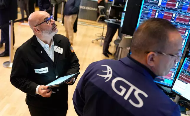 Federico DeMarco works on the floor at the New York Stock Exchange in New York, Tuesday, Jan. 6, 2026. (AP Photo/Seth Wenig)