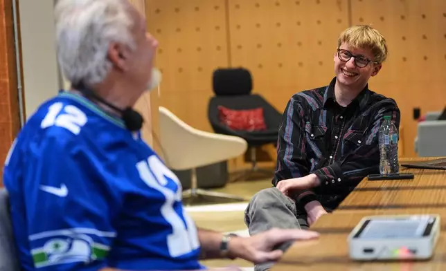 OneCourt founder Jerred Mace, right, talks with Clark Roberts, a blind Seattle Seahawks fan who has had the chance to try out OneCourt tablet, a tactile device that vibrates on key plays and provides real-time audio of games, at the T-Mobile Innovation Hub Tuesday, Jan. 27, 2026, in Bellevue, Wash. (AP Photo/Lindsey Wasson)