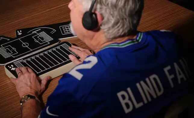 Clark Roberts, a blind Seattle Seahawks fan, uses a OneCourt tablet, a tactile device that translates gameplay into trackable vibrations along with real-time audio, at the T-Mobile Innovation Hub Tuesday, Jan. 27, 2026, in Bellevue, Wash. (AP Photo/Lindsey Wasson)