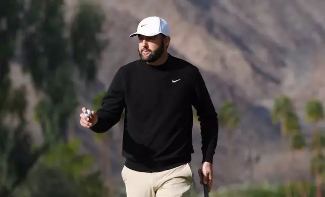 Scottie Scheffler waves to the crowd after making a birdie putt at the first hole during the first round of the American Express golf event at La Quinta County Club Thursday, Jan. 22, 2026, in La Quinta, Calif. (AP Photo/Ross D. Franklin)