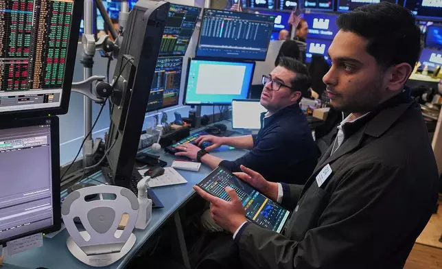 Traders Joseph Lawler, left, and Niall Pawa work on the floor of the New York Stock Exchange, Thursday, Jan. 22, 2026. (AP Photo/Richard Drew)