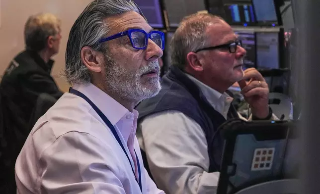 Traders John Romolo, left, and Michael Conlon work on the floor of the New York Stock Exchange, Thursday, Jan. 22, 2026. (AP Photo/Richard Drew)