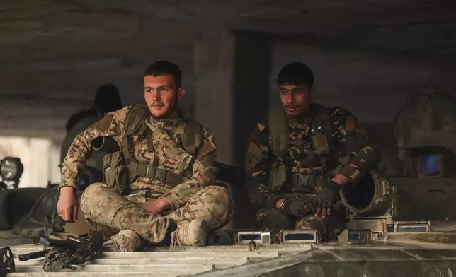 Syrian government soldiers sit on their armoured personnel carrier (APC) following clashes with Kurdish fighters in a contested area of the northern city of Aleppo, Syria, Wednesday, Jan. 7, 2026. (AP Photo/Ghaith Alsayed)