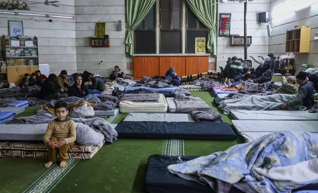 Residents displaced from the Sheikh Maqsoud and Achrafieh neighborhoods take shelter inside a mosque in Aleppo, Syria, Thursday, Jan. 8, 2026, after clashes erupted Tuesday between Syrian government forces and Kurdish fighters in a contested area of Aleppo. (AP Photo/Ghaith Alsayed)