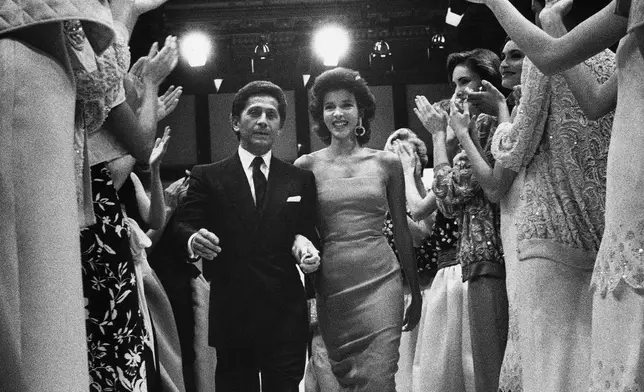 FILE - Famed Italian designer Valentino Garavani, is applauded by his models, after he presented his Spring-Summer High fashion collection in a Rome hotel, Italy on Thursday, Jan. 24, 1985. (AP Photo/Massimo Sambucetti, File)