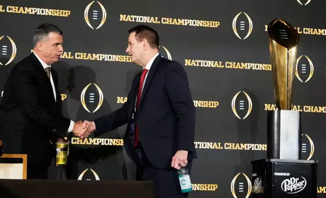 Miami head coach Mario Cristobal and Indiana head coach Curt Cignetti shake hands after a news conference ahead of the College Football Playoff national championship game between Miami and Indiana, Sunday, Jan. 18, 2026, in Miami. The game will be played on Monday. (AP Photo/Chris Carlson)
