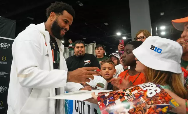 Miami defensive lineman Akheem Mesidor signs during media day ahead of the College Football Playoff national championship game between Miami and Indiana, Sunday, Jan. 17, 2027, in Miami. The game will be played on Monday. (AP Photo/Marta Lavandier)