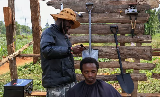 Safari Martins, a barber whose creative techniques have gained him an online following, shaves Ian Njenga in Kiambu, Kenya, Wednesday, Nov. 26, 2025. (AP Photo/Andrew Kasuku)
