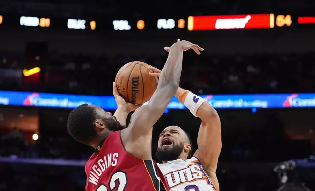 Phoenix Suns guard/forward Dillon Brooks (3) reacts as he is fouled by Miami Heat forward Andrew Wiggins (22) during the first half of an NBA basketball game, Tuesday, Jan. 13, 2026, in Miami. (AP Photo/Rebecca Blackwell)