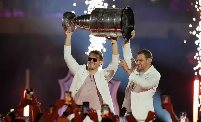 Florida Panthers's Matthew Tkachuk, left, and Aleksander Barkov hold up the Stanley Cup at the NHL Winter Classic outdoor hockey game, Friday, Jan. 2, 2026, in Miami. (AP Photo/Lynne Sladky)