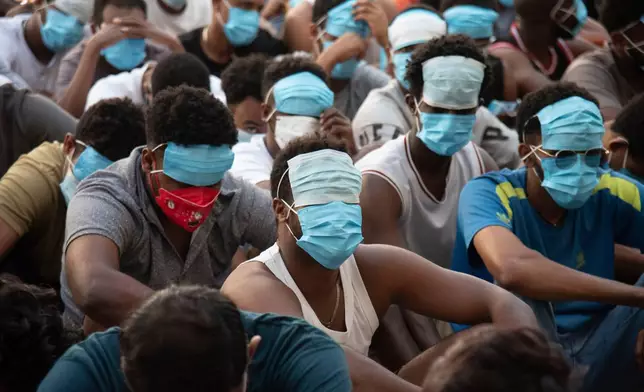 FILE - People from China, Vietnam and Ethiopia, believed to have been trafficked and forced to work in scam centers, sit with their faces masked while in detention after being released from the centers in Myawaddy district in eastern Myanmar, Feb. 26, 2025. (AP Photo/Thanaphon Wuttison, File)