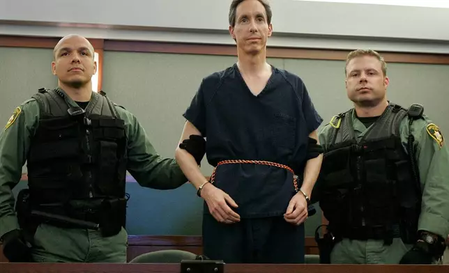FILE - Warren Jeffs appears in a courtroom surrounded by guards in Las Vegas, on Aug. 31, 2006. (AP Photo/Laura Rauch, File)