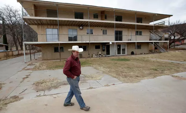 FILE - Isaac Wyler, a former member of The Fundamentalist Church of Jesus Christ of Latter-Day Saints (FLDS), stands in front of an evicted polygamous property, in Hildale, Utah, on Dec. 16, 2014. (AP Photo/Rick Bowmer, File)