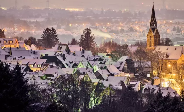 Freshly fallen snow lies on the roofs of houses in Kronberg near Frankfurt, Germany, early Tuesday, Jan. 6, 2026. (AP Photo/Michael Probst)
