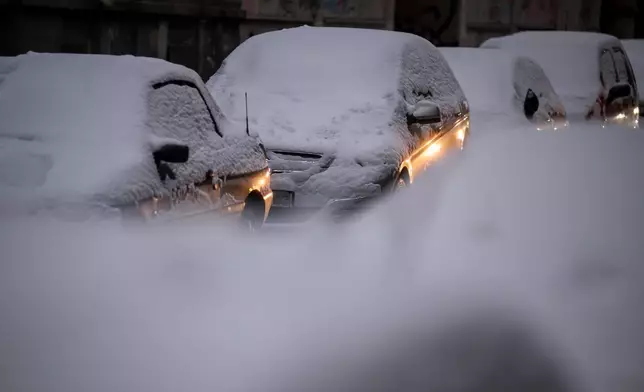 Snow-covered cars are parked in a street in Budapest, Hungary, Tuesday, Jan. 6, 2026. (Zoltan Balogh/MTI via AP)