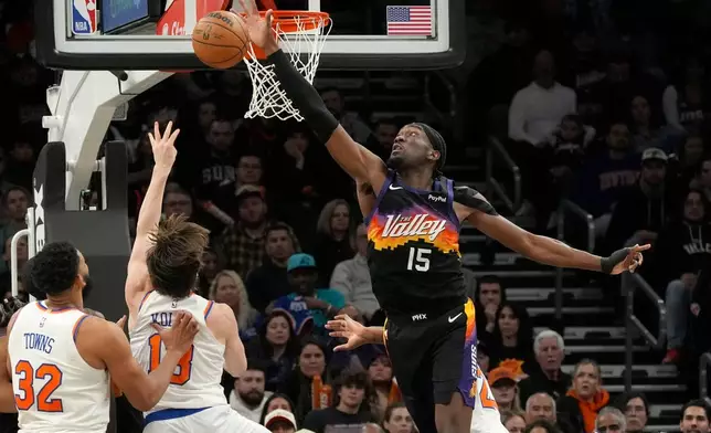 Phoenix Suns center Mark Williams (15) blocks a shot by New York Knicks guard Tyler Kolek as Knicks center Karl-Anthony Towns (32) looks on during the second half of an NBA basketball game, Friday, Jan. 9, 2026, in Phoenix. (AP Photo/Ross D. Franklin)