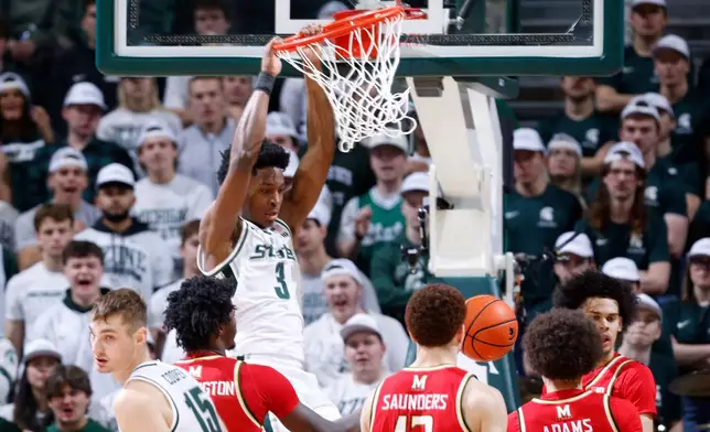 Michigan State forward Cam Ward (3) dunks over Maryland forward Solomon Washington, left, forward Elijah Saunders (13) and guard Darius Adams, right, during the first half of an NCAA college basketball game, Saturday, Jan. 24, 2026, in East Lansing, Mich. (AP Photo/Al Goldis)
