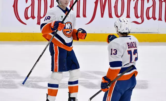New York Islanders' Matthew Schaefer (48) celebrates his goal against the Winnipeg Jets with Mathew Barzal (13) during the third period of an NHL hockey game in Winnipeg, Manitoba, Tuesday, Jan. 13, 2026. (Fred Greenslade/The Canadian Press via AP)