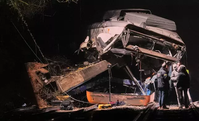 Emergency crews respond after a commuter train derailed when a retaining wall collapsed onto the tracks in Gelida, near Barcelona, Spain, Tuesday, Jan. 20, 2026. (AP Photo/Joan Mateu Parra)