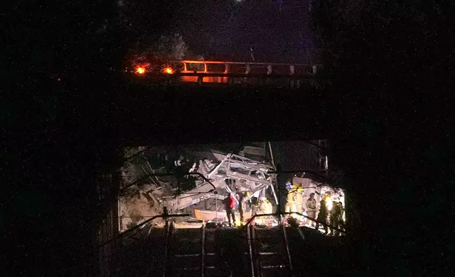 Emergency crews respond after a commuter train derailed when a retaining wall collapsed onto the tracks in Gelida, near Barcelona, Spain, Tuesday, Jan. 20, 2026. (AP Photo/Joan Mateu Parra)