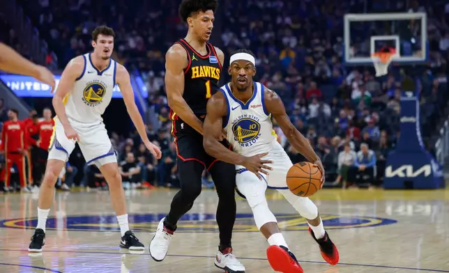 Golden State Warriors Jimmy Butler III (10) dribbles the ball past Atlanta Hawks Jalen Johnson (1) during the first half an an NBA basketball game in San Francisco, Sunday, Jan. 11, 2026. (Carlos Avila Gonzalez/San Francisco Chronicle via AP)