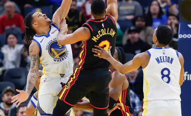Atlanta Hawks CJ McCollum (3) and Golden State Warriors Will Richard (3) jump to the hoop during the first half of an NBA basketball game in San Francisco, Sunday, Jan. 11, 2026. (Carlos Avila Gonzalez/San Francisco Chronicle via AP)