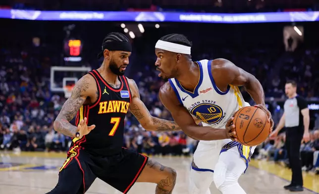 Golden State Warriors Jimmy Butler III (10) moves with the ball around Atlanta Hawks Nickeil Alexander-Walker (7) during the third quarter of an NBA basketball game in San Francisco, Sunday, Jan. 11, 2026. (Carlos Avila Gonzalez/San Francisco Chronicle via AP)