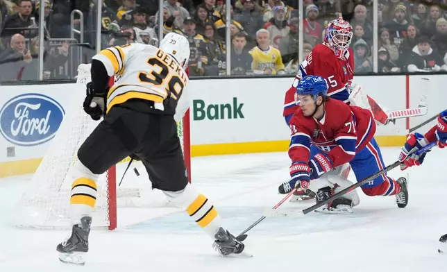 Boston Bruins center Morgan Geekie (39) scores a goal with Montreal Canadiens goaltender Samuel Montembeault (35) out of position in the second period of an NHL hockey game in Boston, Saturday, Jan. 24, 2026. (AP Photo/Robert F. Bukaty)