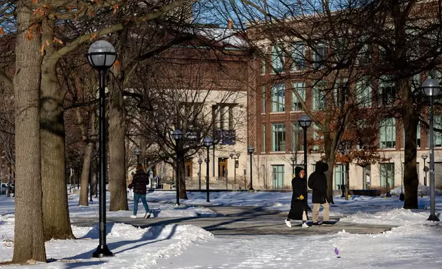 People walk around the University of Michigan campus in Ann Arbor, Mich., Jan. 17, 2026. (AP Photo/Emily Elconin)