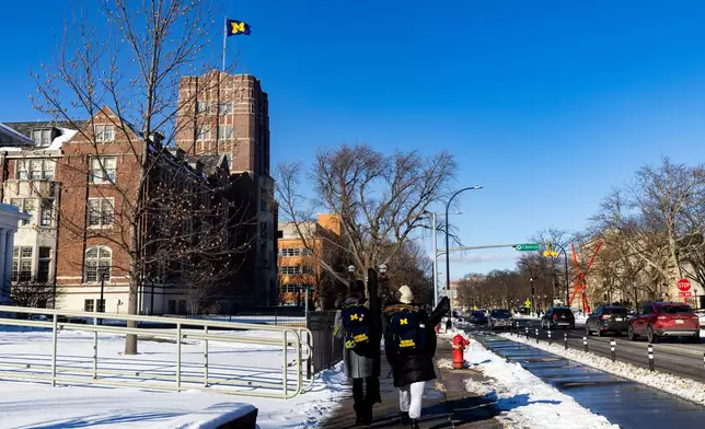 Students walk around the University of Michigan campus in Ann Arbor, Mich., Jan. 17, 2026. (AP Photo/Emily Elconin)