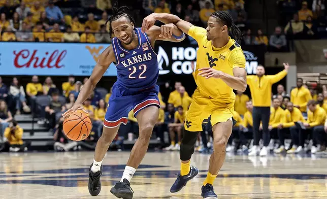 Kansas guard Darryn Peterson (22) is defended by West Virginia guard Jasper Floyd (1) during the second half of an NCAA college basketball game Saturday, Jan. 10, 2026, in Morgantown, W.Va. (AP Photo/Kathleen Batten)