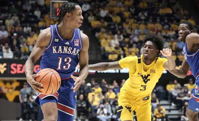 Kansas guard Elmarko Jackson (13) is defended by West Virginia guard Honor Huff (3) during the second half of an NCAA college basketball game Saturday, Jan. 10, 2026, in Morgantown, W.Va. (AP Photo/Kathleen Batten)