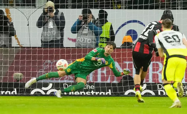 Frankfurt's Can Uzun, second right, scores his side's opening goal past Dortmund's goalkeeper Gregor Kobel during the Bundesliga soccer match between Eintracht Frankfurt and Borussia Dortmund in Frankfurt, Germany, Friday, Jan. 9, 2026. (AP Photo/Michael Probst)