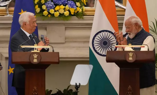 European Council President Antonio Costa, left, shows his Overseas Citizen of India (OCI) card to Indian Prime Minister Narendra Modi, during his press statement after reaching free trade agreement between India and EU in New Delhi, India, Tuesday, Jan. 27, 2026. (AP Photo/Manish Swarup)