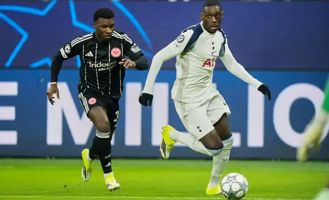 Tottenham's Randal Kolo Muani, right, and Eintracht's Buta challenge for the ball during the Champions League opening phase soccer match between Eintracht Frankfurt and Tottenham Hotspurs in Frankfurt, Germany, Wednesday, January. 28, 2026. (AP Photo/Michael Probst)