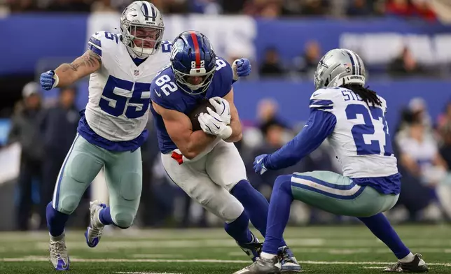 New York Giants tight end Daniel Bellinger (82) carries the ball against Dallas Cowboys cornerback Reddy Steward (27) and linebacker Logan Wilson (55) during the second quarter of an NFL football game, Sunday, Jan. 4, 2026, in East Rutherford, N.J. (AP Photo/Adam Hunger)