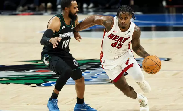 Miami Heat guard Davion Mitchell (45) drives up the court against Minnesota Timberwolves guard Mike Conley (10) during the first half of an NBA basketball game, Tuesday, Jan. 6, 2026, in Minneapolis. (AP Photo/Ellen Schmidt)