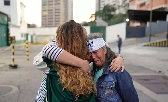 Flor Zambrano, whose son, Rene Chourio, she says is detained at Zone 7 of the Bolivarian National Police for political reasons, embraces relatives of other detainees outside the facility in Caracas, Venezuela, Monday, Jan. 12, 2026. (AP Photo/Matias Delacroix)