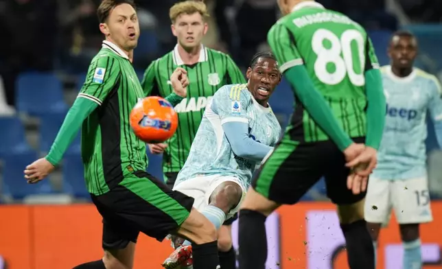 Juventus' Jonathan David battles for the ball with Sassuolo's Nemanja Matic, left, and Tarik Muharemovic during the Serie A soccer match between Sassuolo and Juventus, in Reggio Emilia, Italy, Tuesday, Jan. 6, 2026. (Massimo Paolone/LaPresse via AP)