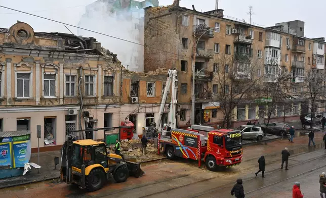 Rescue workers clear the rubble of a residential building which was heavily damaged after a Russian strike in Odesa, Ukraine, Tuesday, Jan. 27, 2026. (AP Photo/Michael Shtekel)