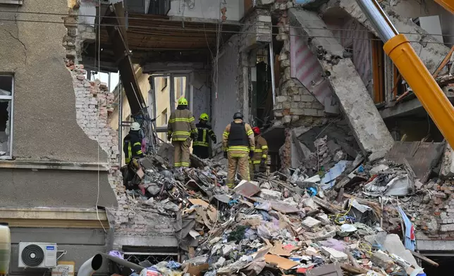 Rescue workers clear the rubble of a residential building which was heavily damaged after a Russian strike in Odesa, Ukraine, Tuesday, Jan. 27, 2026. (AP Photo/Michael Shtekel)