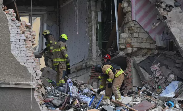 Rescue workers clear the rubble of a residential building which was heavily damaged after a Russian strike in Odesa, Ukraine, Tuesday, Jan. 27, 2026. (AP Photo/Michael Shtekel)